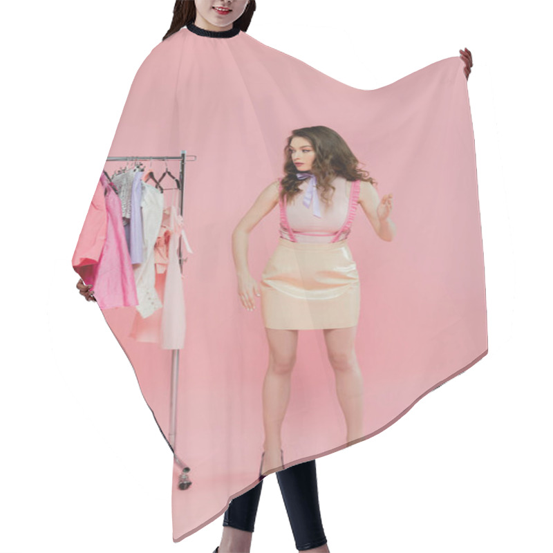 Personality  Wardrobe Selection, Beautiful Young Woman With Wavy Hair Choosing Clothes, Pretending To Be A Doll, Gesturing With Hands While Standing Near Clothes Rack, Pink Background  Hair Cutting Cape