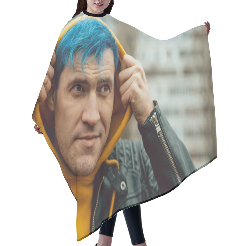 Personality  Portrait Of Young Man In Hood On Background Of High-rise Building. Handsome Guy With Blue Hair Posing On City Street In Springtime Hair Cutting Cape