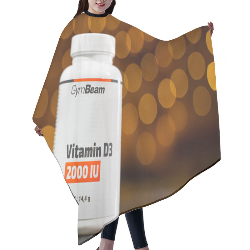 Personality  Kyiv, Ukraine - January 8, 2025: Plastic Jar With Vitamin D3 Capsules From GymBeam Company Close-up On A Blurred Background. Hair Cutting Cape