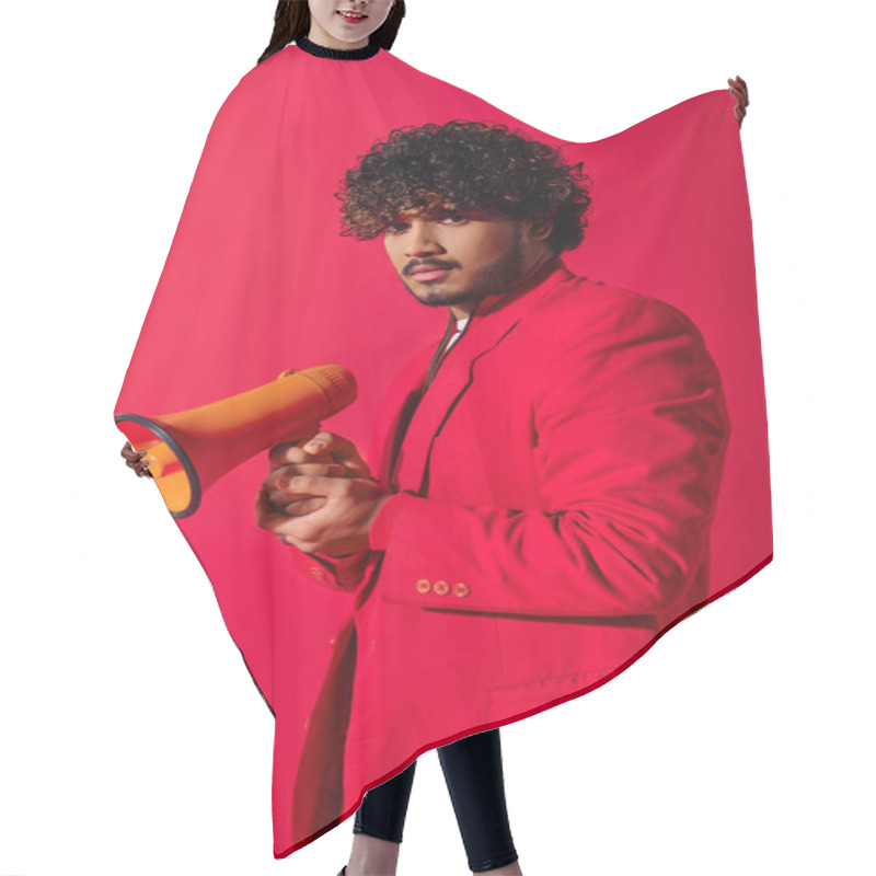 Personality  Young Indian Man In Red Suit Holding Red And Yellow Megaphone. Hair Cutting Cape