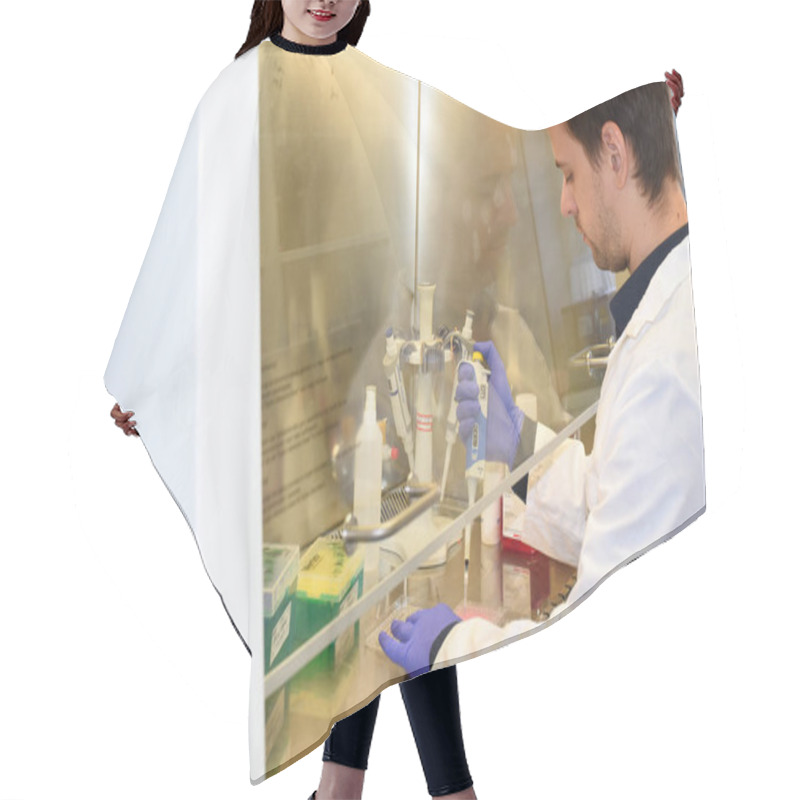 Personality  PRAGUE, CZECH REPUBLIC - October 27, 2019: Biologist Working Under Laminar Hood Transferring Cells Under Sterile Conditions. Institute Of Organic And Biochemistry. Hair Cutting Cape