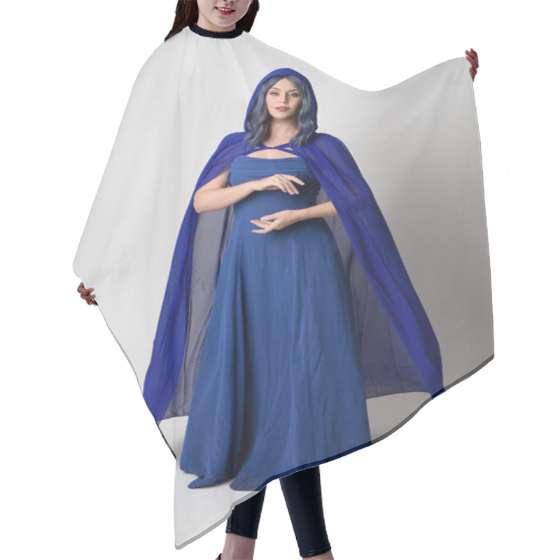 Personality  Full Length Portrait Of Beautiful Female Model Wearing Elegant Fantasy Blue Ball Gown And Flowing Cape With Hood.Standing Pose, With Gestural Arms Reaching Out . Isolated On White Studio Background. Hair Cutting Cape