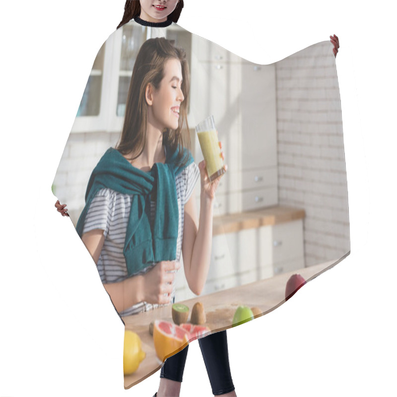 Personality  Joyful Woman Holding Glass Of Smoothie Near Fresh Fruits In Kitchen, Blurred Foreground Hair Cutting Cape