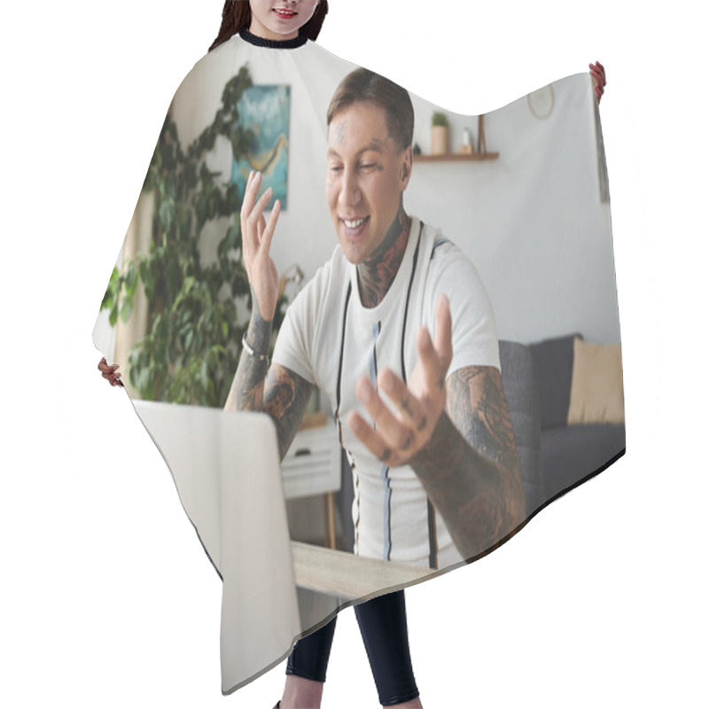 Personality  Tattooed Man Happily Interacts On Laptop While Sitting In Modern Living Space Hair Cutting Cape