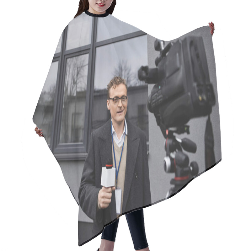 Personality  A Professional Journalist In Glasses Speaks Into A Microphone While Standing Near A Camera Outdoors. Hair Cutting Cape