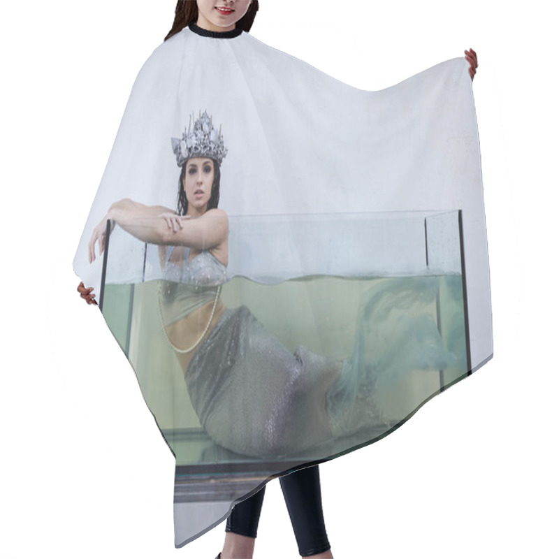 Personality  A Young Woman, Adorned In A Shimmering Crown And Mermaid Tail, Gazes From Within A Water-filled Tank. Hair Cutting Cape