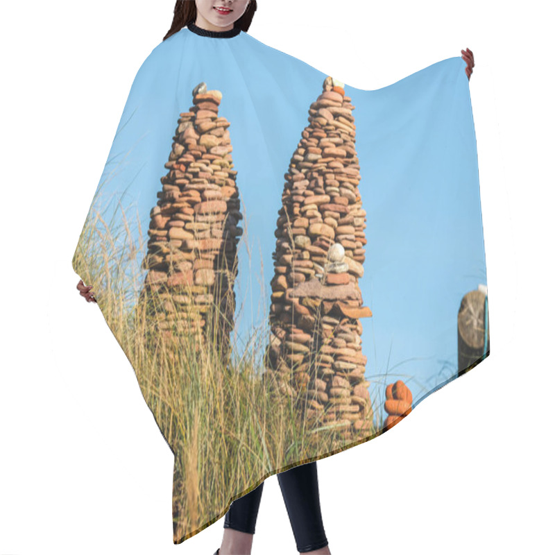 Personality  Two Intricately Stacked Stone Towers Rise From A Grassy Hill Against A Clear Blue Sky, Showcasing Nature-inspired Artistry. Hair Cutting Cape