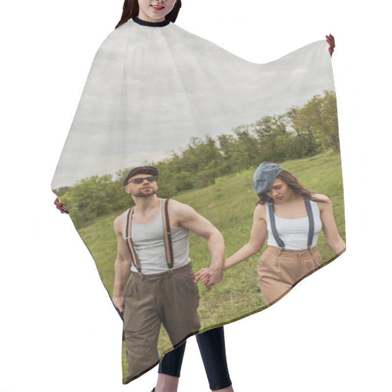 Personality  Fashionable Bearded An In Sunglasses And Suspenders Holding Jacket And Hand Of Brunette Girlfriend In Newsboy Cap And Walking On Grassy Lawn, Trendy Couple In The Rustic Outdoors Hair Cutting Cape