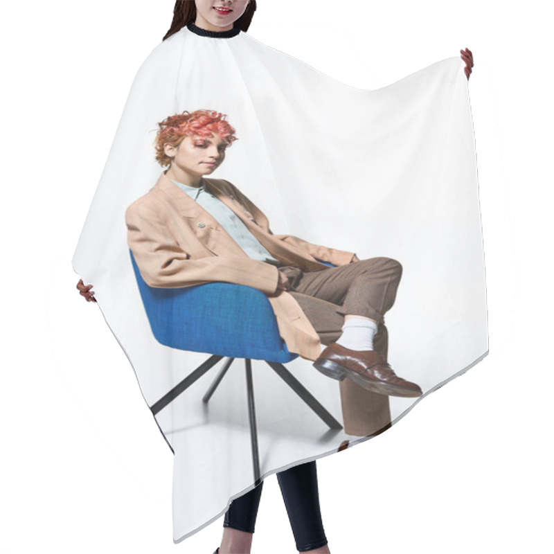 Personality  Extraordinary Woman With Fiery Red Hair Relaxes On A Sleek Blue Chair. Hair Cutting Cape