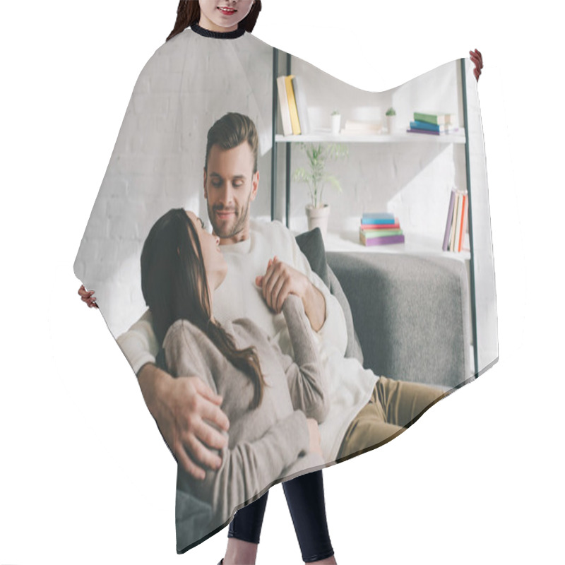 Personality  Happy Young Couple Relaxing On Couch And Holding Hands At Home Hair Cutting Cape