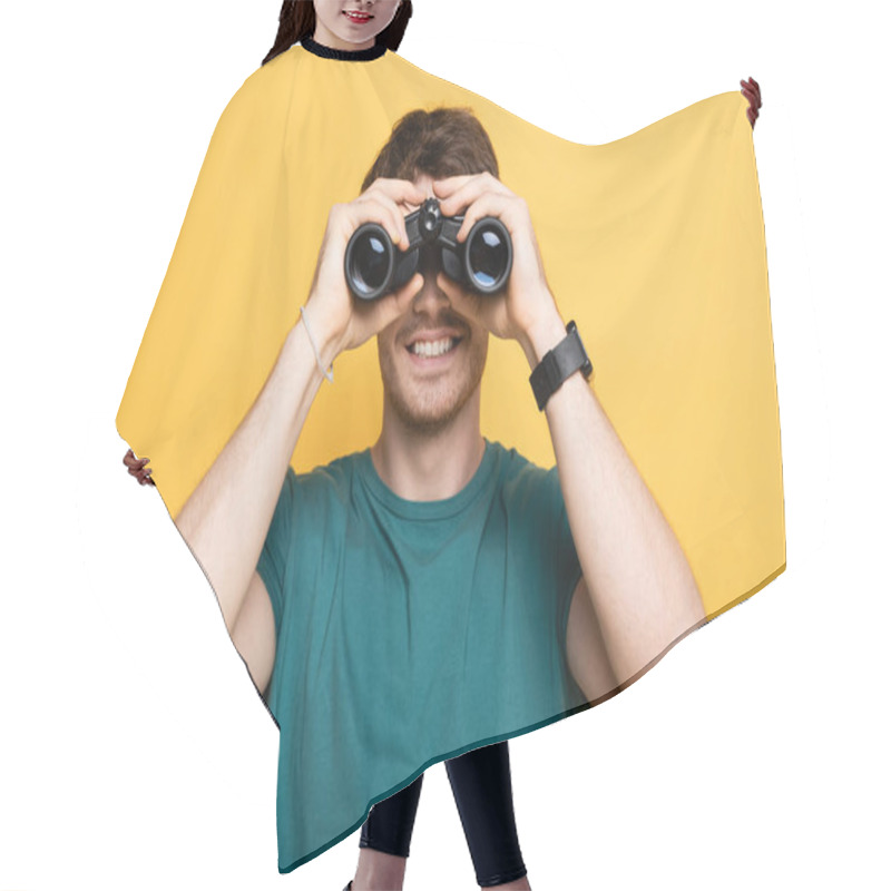 Personality  Cheerful Man Looking Through Binoculars On Yellow Hair Cutting Cape