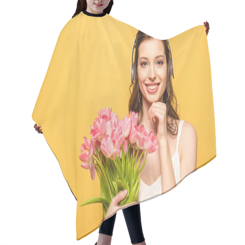 Personality  Pretty Young Woman In Wireless Headphones Smiling At Camera While Holding Bouquet Of Tulips Isolated On Yellow Hair Cutting Cape