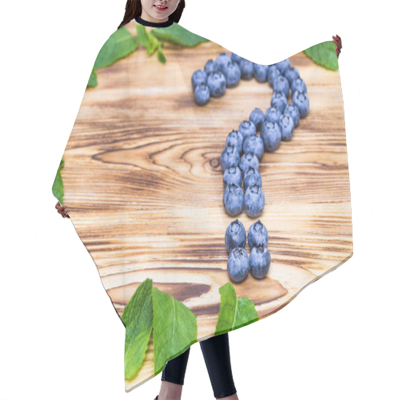 Personality  Question Sign Made Of Fresh Ripe Natural Blueberries With Bright Green Spearmint Frame On A Brushed Wooden Background. Healthy Diet  Question Concept Hair Cutting Cape