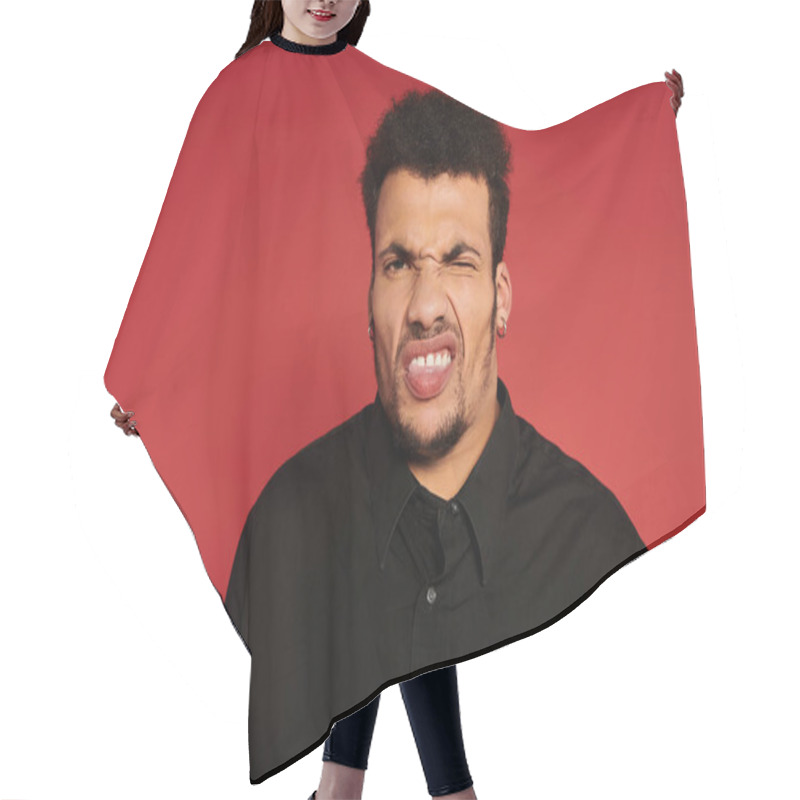 Personality  A Handsome Young Man Poses Playfully With A Silly Expression In A Vibrant Studio. Hair Cutting Cape