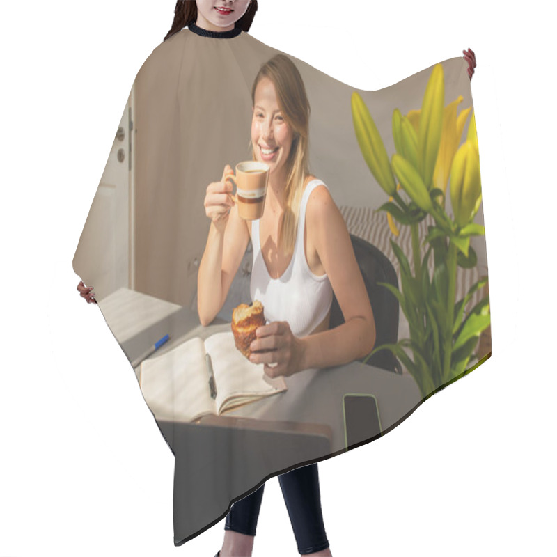 Personality  Positive Freelancer Holding Coffee And Croissant Near Devices And Flowers At Home  Hair Cutting Cape