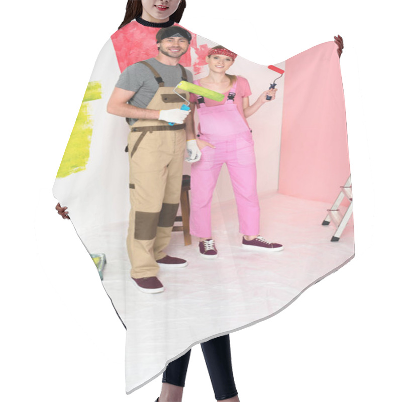 Personality  Smiling Young Couple In Working Overalls Standing With Paint Rollers  Hair Cutting Cape