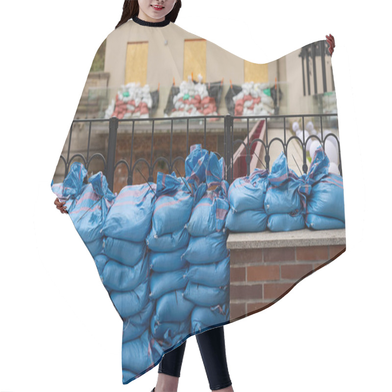 Personality  Protective Barrier Of Blue Sandbags Stacked Along Building To Shield Property From Flooding And Rising Waters, Emphasizing Precautionary Measures For Flood Defense In Urban Environment Hair Cutting Cape