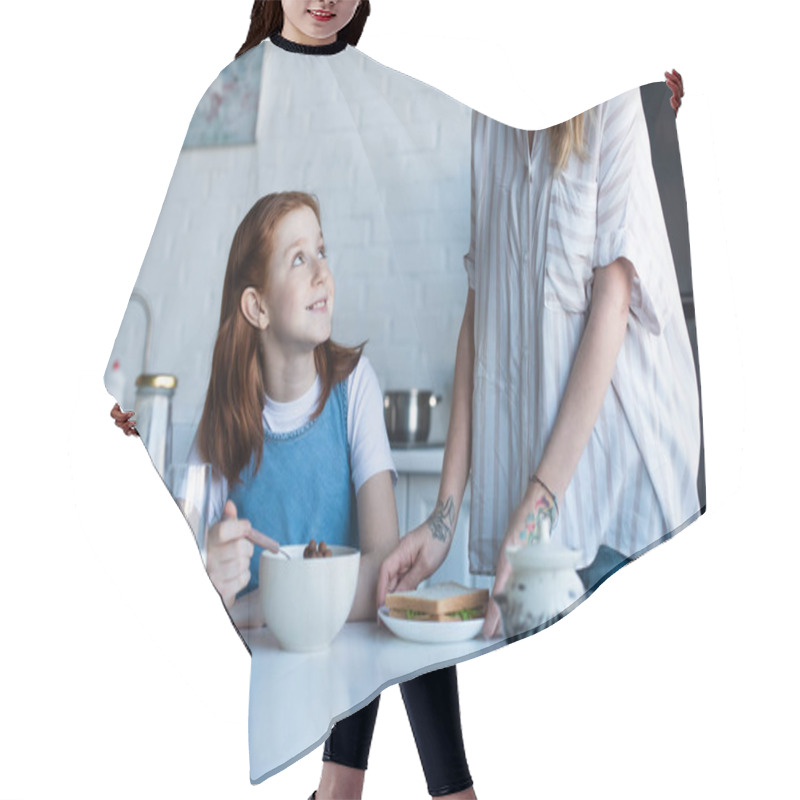 Personality  Cheerful Girl Eating Delicious Corn Flakes Near Mother In Kitchen Hair Cutting Cape