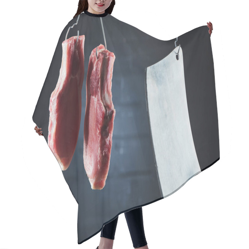 Personality  Raw Pork Steaks And Butcher Knife On Metal Hooks On Dark Black Background Hair Cutting Cape