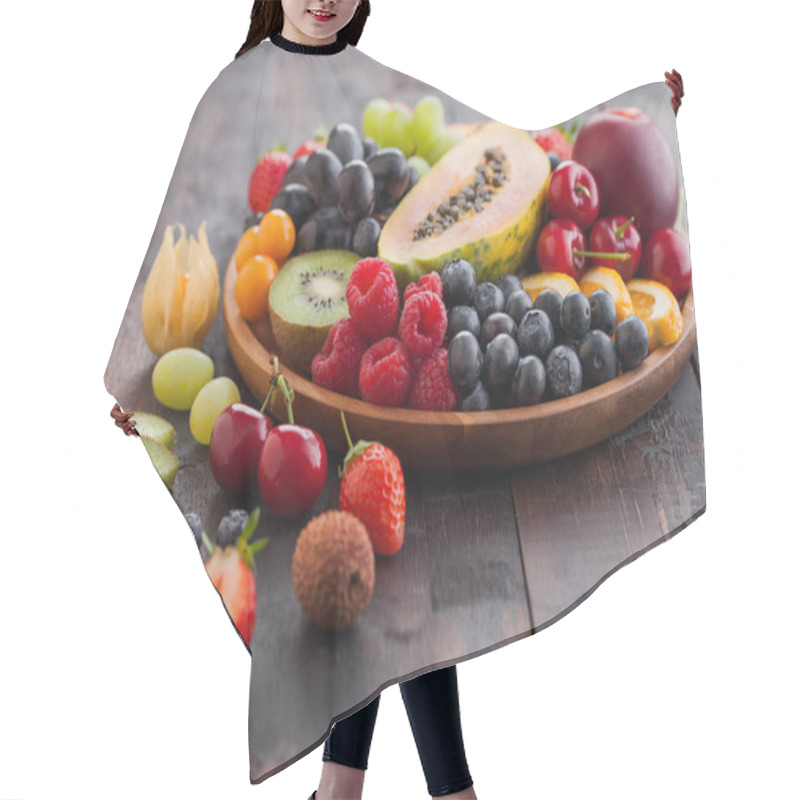 Personality  Fresh Raw Organic Summer Berries And Exotic Fruits In Round Wooden Plate On Dark Wooden Kitchen Background. Papaya, Grapes, Nectarine, Orange, Raspberry, Kiwi, Strawberry, Lychees, Cherry. Top View Hair Cutting Cape