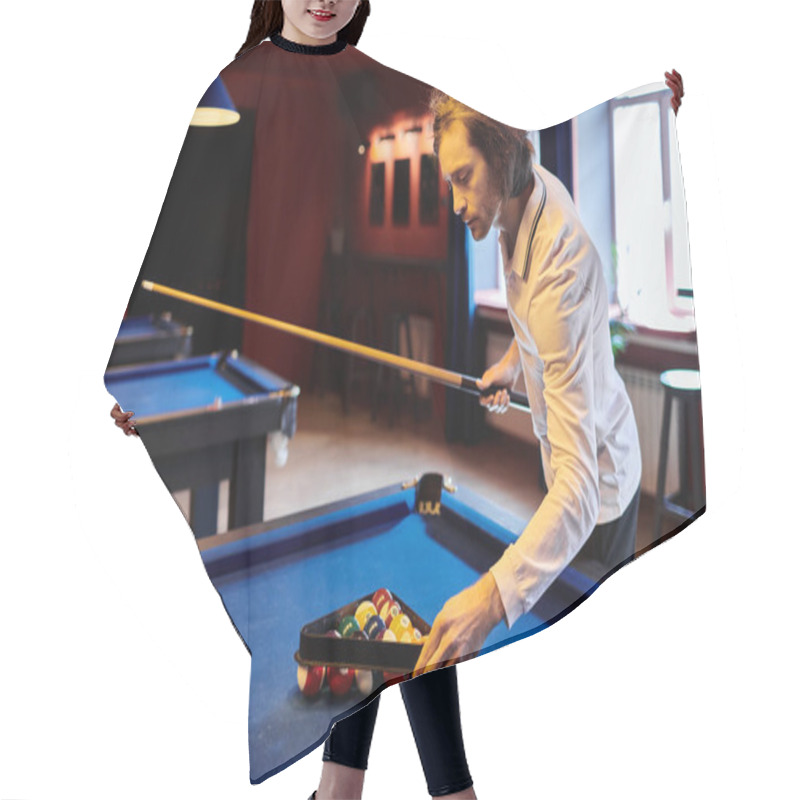 Personality  A Man In A Casual White Shirt Sets Up A Game Of Billiards In A Dimly Lit Pool Hall. Hair Cutting Cape