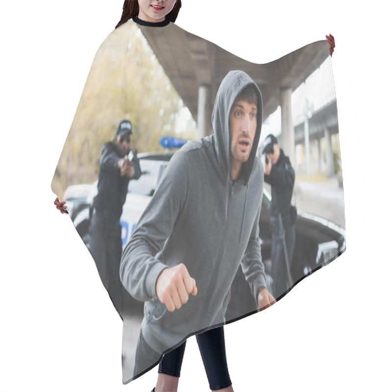 Personality  Scared Hooded Offender Running From Multicultural Police Officers Aiming By Gun On Blurred Background Outdoors Hair Cutting Cape