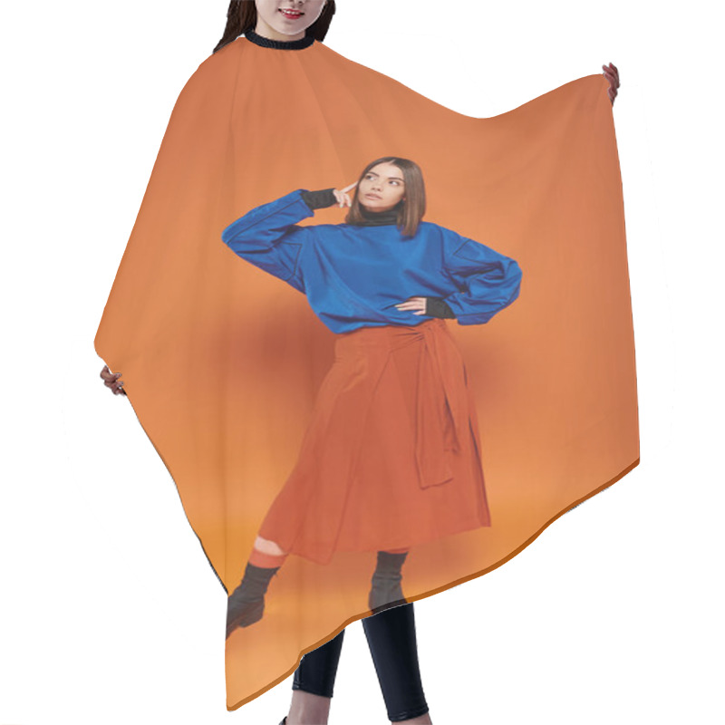 Personality  Pensive Young Woman With Pierced Nose Standing In Autumn Attire With Hand On Hip On Orange Backdrop Hair Cutting Cape