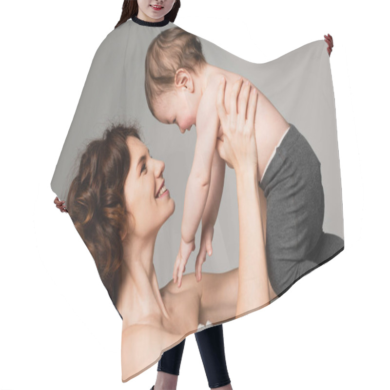 Personality  Happy Mother With Bare Shoulders Holding In Arms Son In Baby Tights Isolated On Grey Hair Cutting Cape