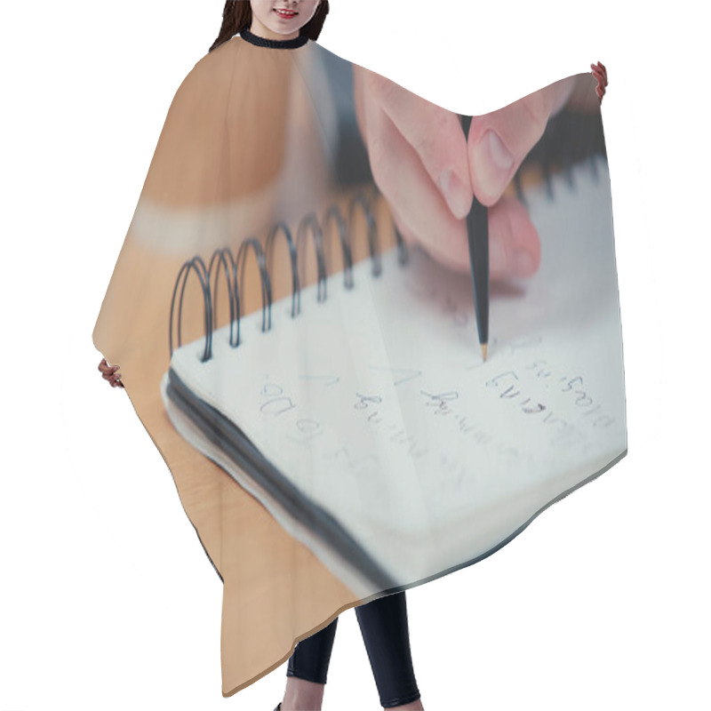 Personality  Cropped View Of Person Holding Pen While Writing In Blurred Notebook  Hair Cutting Cape