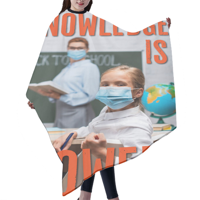 Personality  Selective Focus Of Schoolgirl In Medical Mask Looking At Camera While Teacher Standing Near Chalkboard And Knowledge Is Power Lettering  Hair Cutting Cape