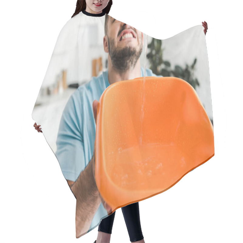 Personality  Selective Focus Of Displeased Bearded Man Holding Plastic Wash Bowl Near Pouring Water  Hair Cutting Cape