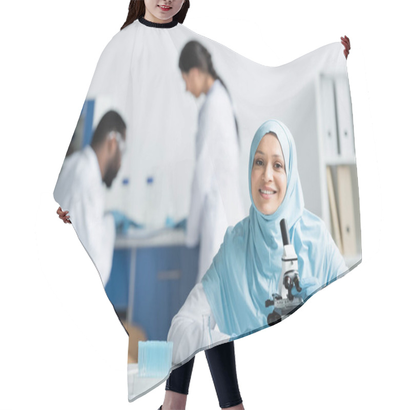 Personality  Positive Muslim Scientist Looking At Camera Near Microscope, Flask And Pipette In Lab  Hair Cutting Cape