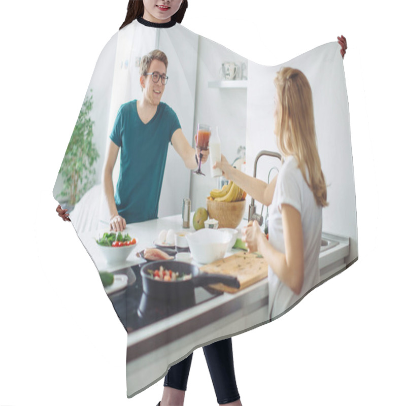 Personality  Attractive Young Woman And Handsome Man Are Enjoying Spending Time Together In Light Modern Kitchen While Toasting With Bottle Of Milk And Smoothie In Hands. Hair Cutting Cape