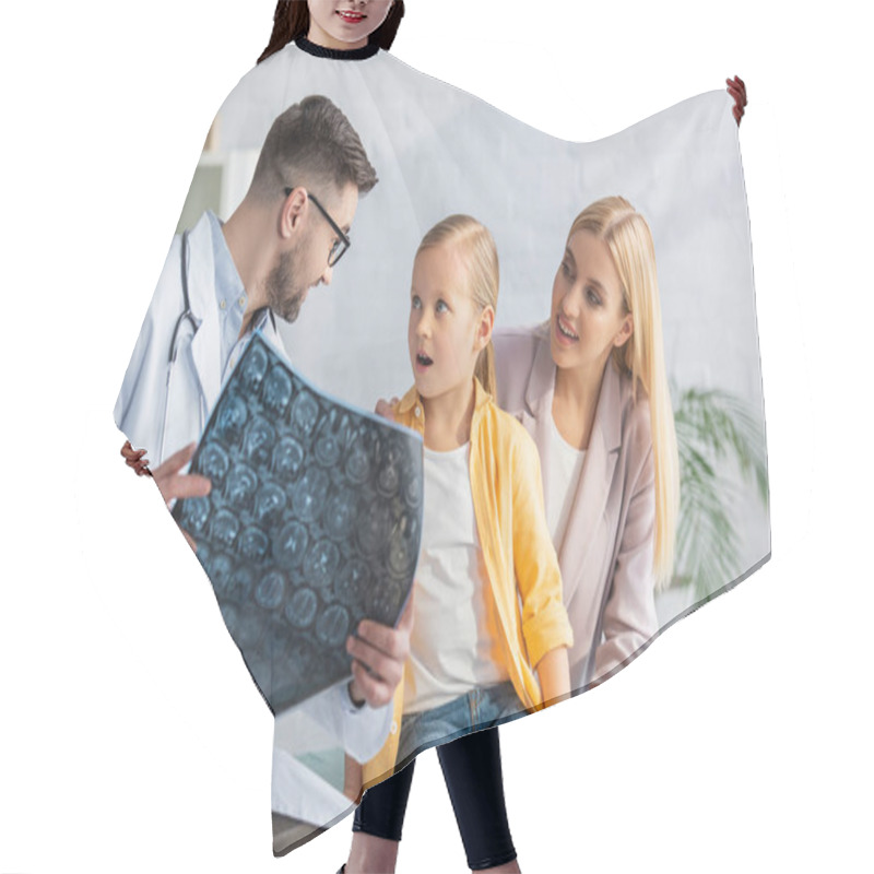 Personality  Pediatrician Holding Blurred Mri Scan Near Amazed Kid And Mother Hair Cutting Cape