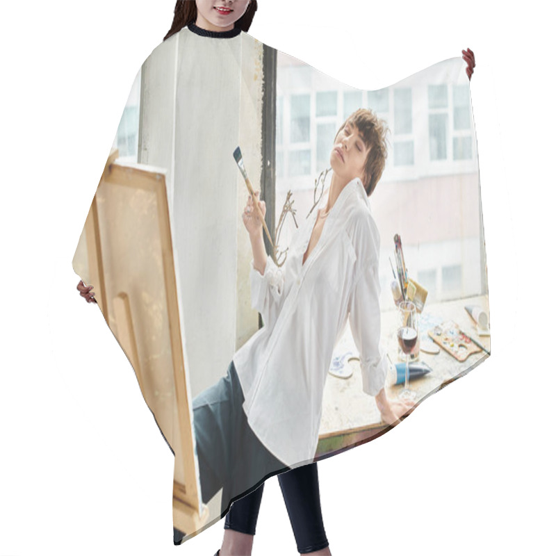 Personality  A Woman Holds A Paintbrush While Standing Next To An Easel. Hair Cutting Cape