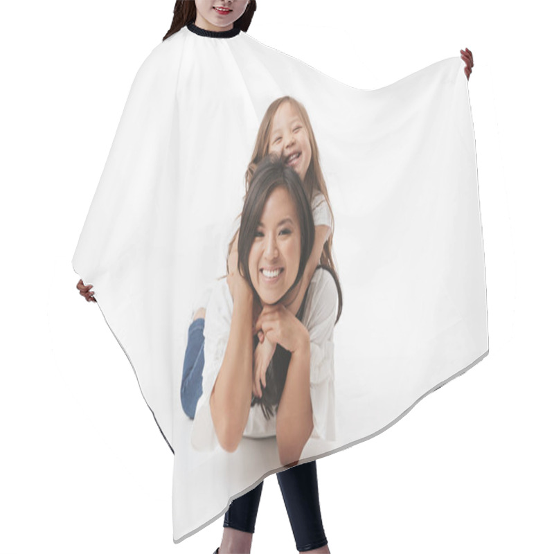 Personality  Image Of Cute Young Asian Woman Mother With Her Little Girl Child Daughter Lies On Floor Isolated Over White Wall Background. Hair Cutting Cape