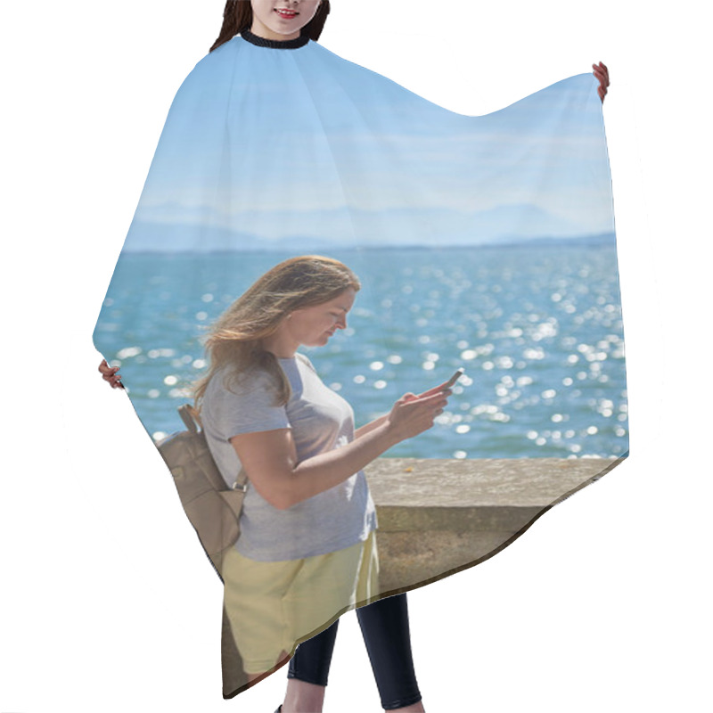 Personality  Woman Capturing Scenic Photos By A Sparkling Lake On A Sunny Day With Majestic Mountain Views. Idyllic Lakeside Setting Showcases Natural Beauty And Outdoor Adventure In A Serene European Landscape Hair Cutting Cape