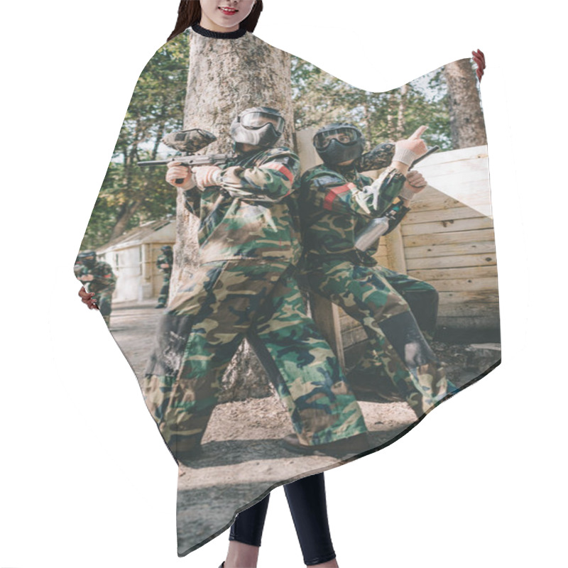 Personality  Male Paintball Player In Goggle Mask And Camouflage Holding Marker Gun And Pointing By Finger To Teammate Near Tree Outdoors  Hair Cutting Cape