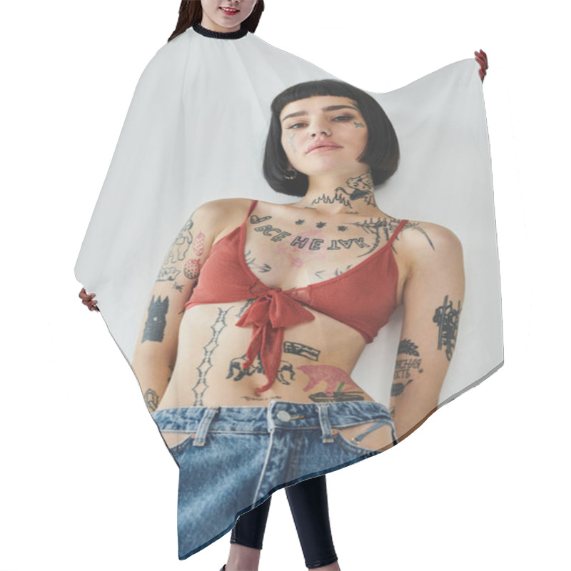 Personality  A Stylish Woman Confidently Displays Her Tattoos And Outfit Against A Plain Backdrop. Hair Cutting Cape