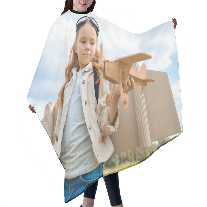 Personality  Portrait Of Red Hair Kid In Pilot Costume Holding Wooden Plane In Summer Field Hair Cutting Cape