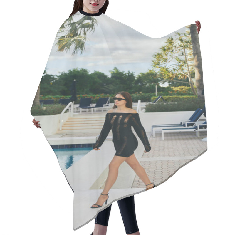 Personality  Seductive Woman In Black Knitted Dress And Sunglasses Walking In High Heels Next To Outdoor Swimming Pool With Shimmering Water Against Palm Trees In Miami, Vacation In Luxury Resort, Sunbeds Hair Cutting Cape