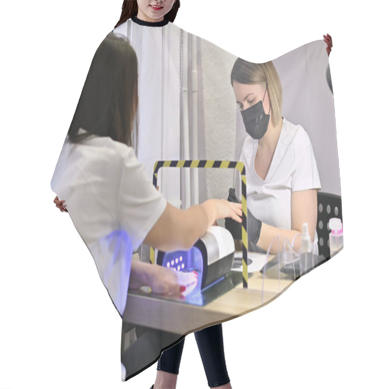 Personality  The Master In A Protective Mask And Gloves Serves The Girl In A Beauty Salon. Work With Clients In Conditions Of Increased Risk Of Infection Hair Cutting Cape