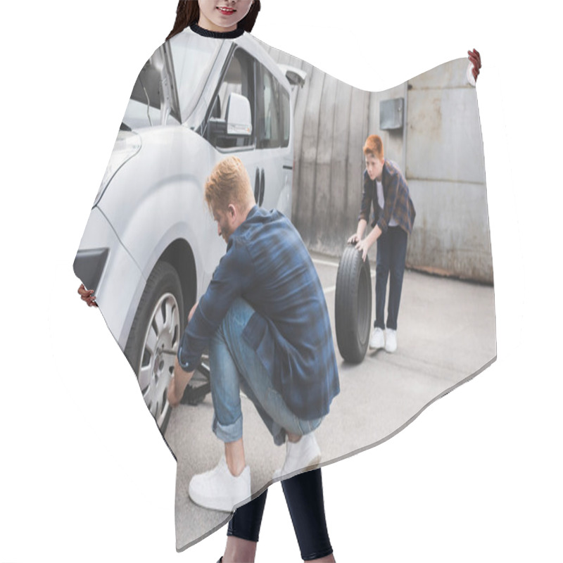 Personality  Father Changing Tire In Car With Wheel Wrench, Son Holding Tire Hair Cutting Cape