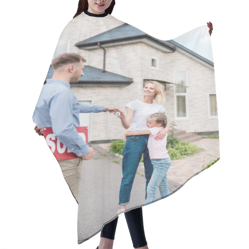 Personality  Smiling Male Realtor With Sold Sign Giving Key To Young Woman With Daughter In Front Of New House Hair Cutting Cape