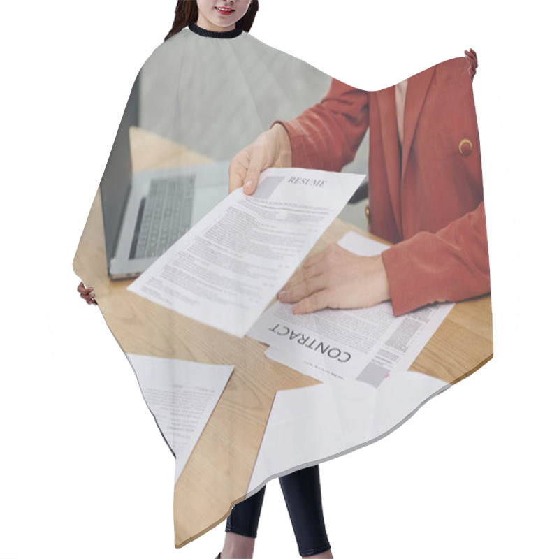 Personality  Woman Carefully Examines A Resume While Seated At A Desk. Hair Cutting Cape