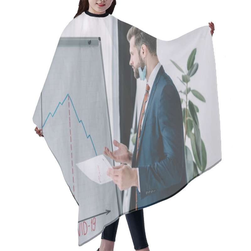 Personality  Serious, Thoughtful Businessman Holding Paper While Standing At Flipchart With Graphs Showing Decrease Hair Cutting Cape