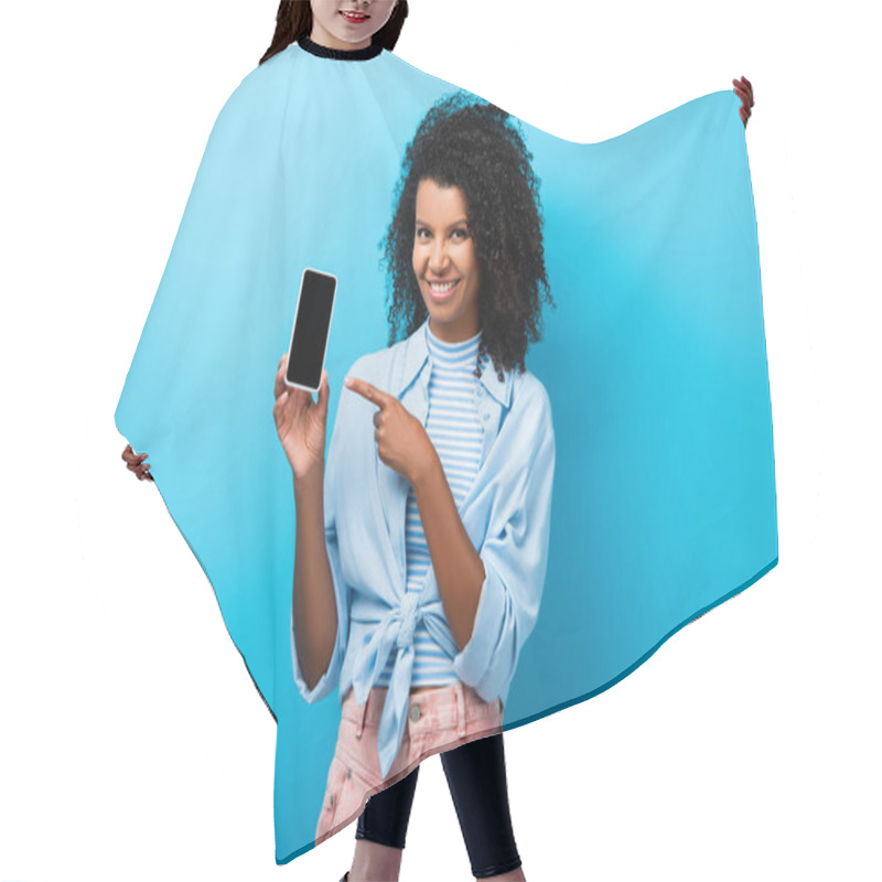 Personality  Happy African American Woman Pointing With Finger At Smartphone With Blank Screen On Blue Hair Cutting Cape