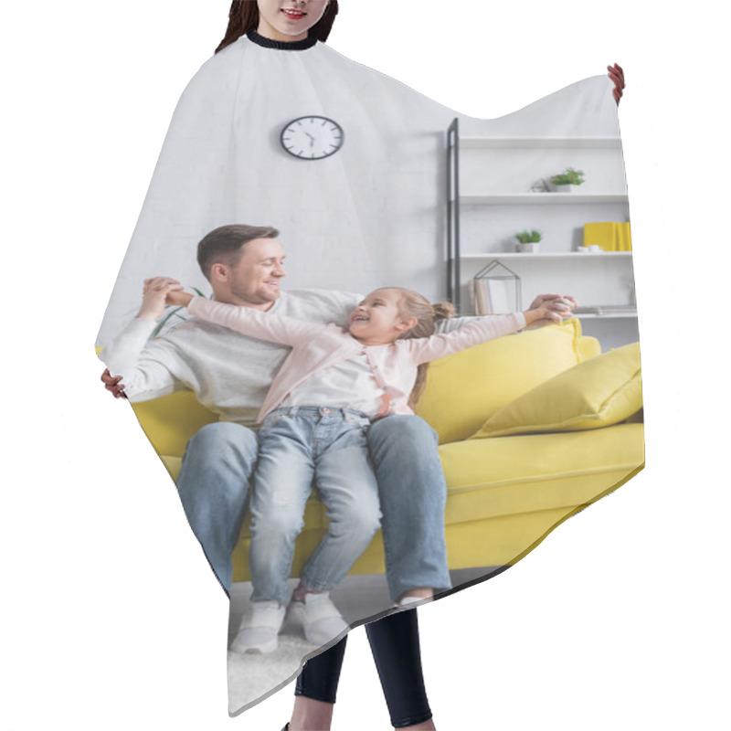 Personality  Smiling Father Holding Hands Of Daughter On Couch  Hair Cutting Cape