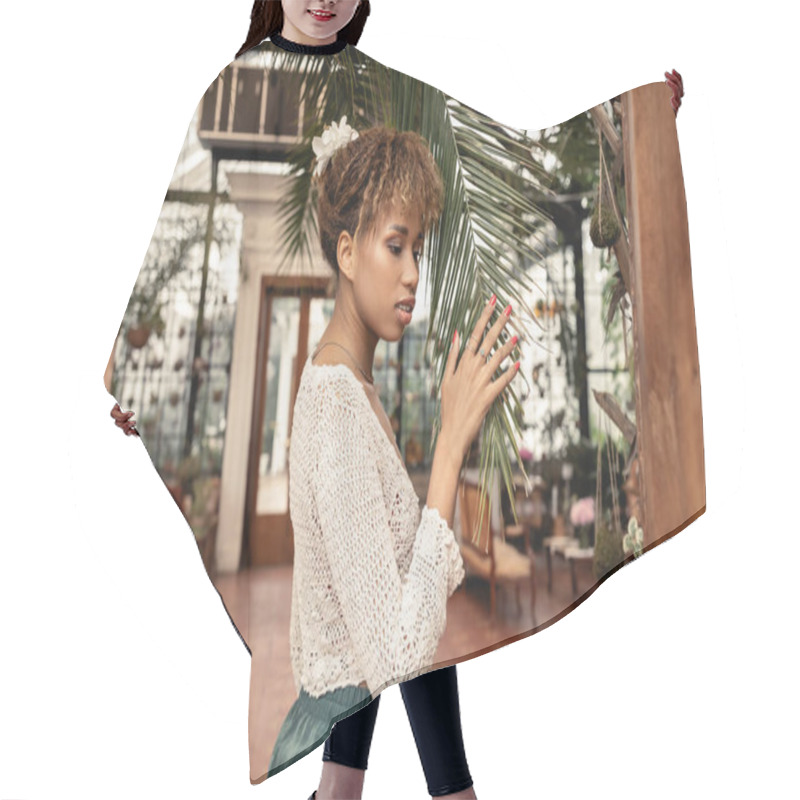 Personality  Young Stylish African American Woman In Summer Knitted Top Touching Branch Of Palm Tree In Blurred Indoor Garden At Background, Fashionista Posing Amidst Tropical Flora, Summer Concept Hair Cutting Cape