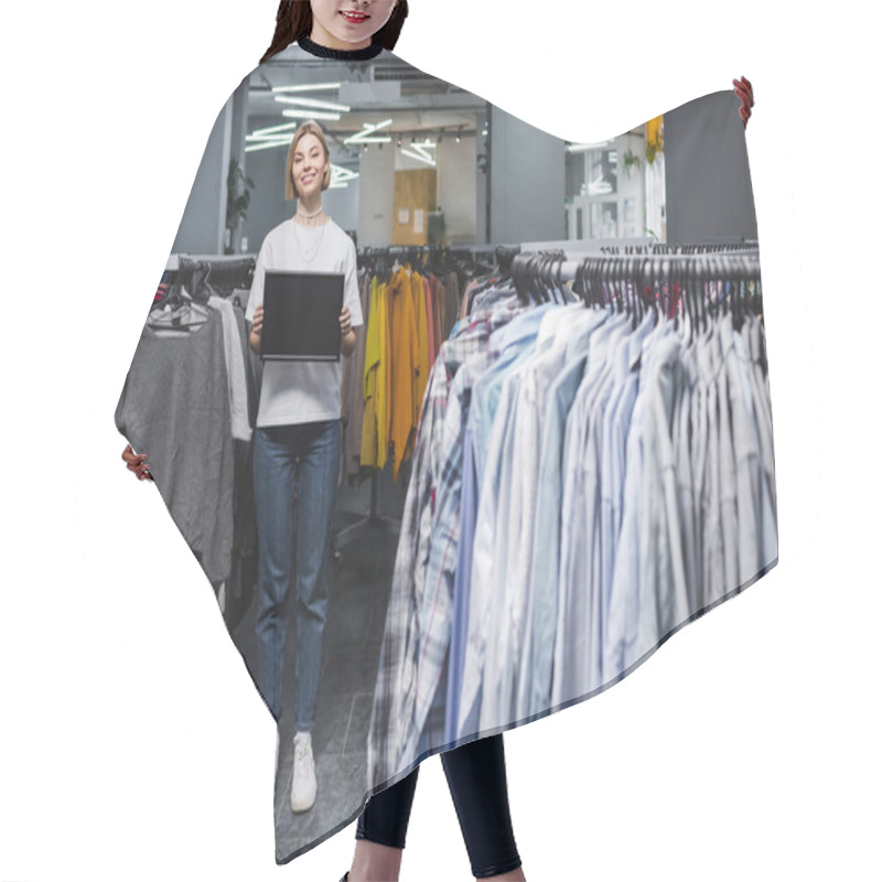 Personality  Smiling Saleswoman Holding Empty Board Near Clothes In Second Hand  Hair Cutting Cape